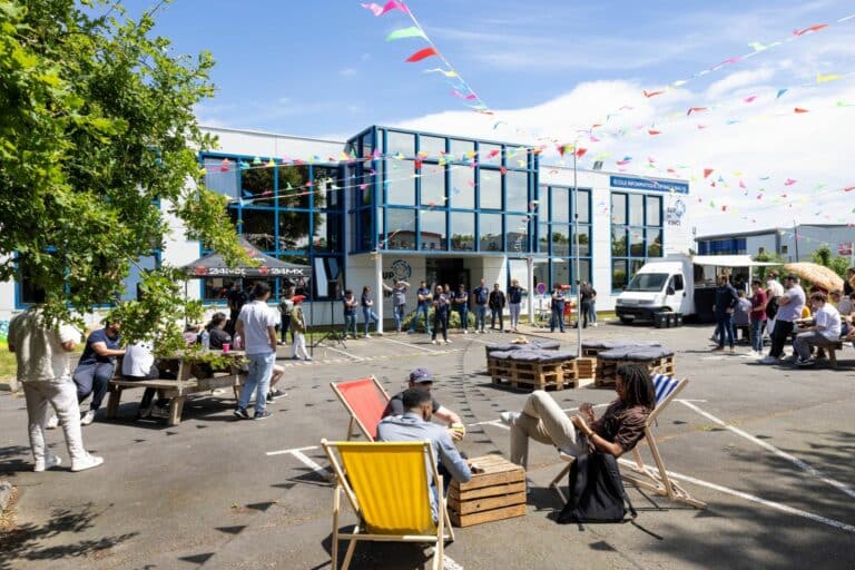 Vue d'ensemble de la Summer Party guinguette avec des guirlandes colorées et des espaces de détente chill à l'école Sup de Vinci à Rennes